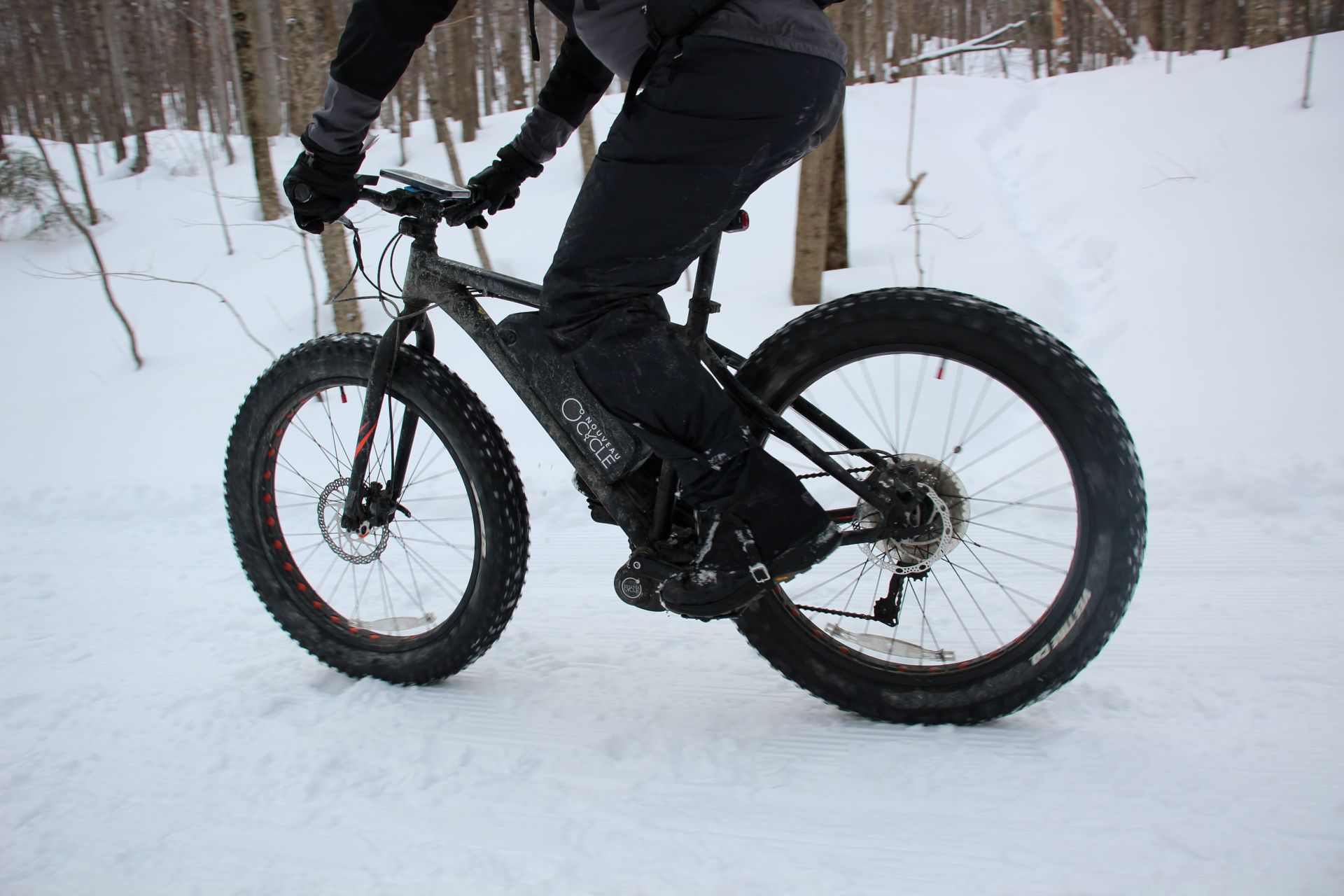 Cycliste avançant dans la neige sur un vélo électrique